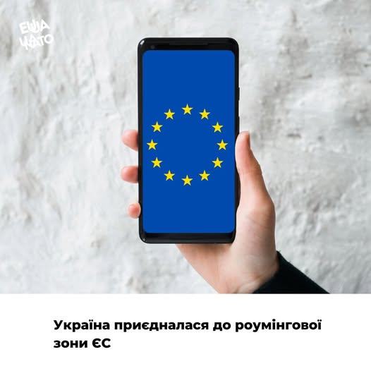 Рука тримає смартфон із зображенням прапора ЄС на екрані, а текст повідомляє, що Україна приєдналася до роумінгової зони ЄС