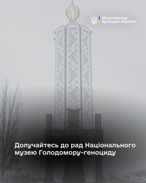 високий, білий пам'ятник у формі "Свічки пам'яті", що є центральним елементом Меморіалу жертв Голодомору в Києві, височіє крізь туман, ілюструючи заклик Міністерства культури України долучитися до формування Експертної та Наглядової рад Національного музею Голодомору-геноциду.
