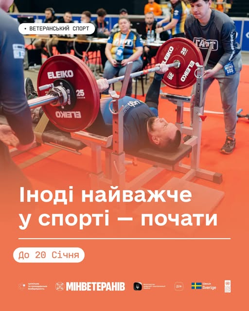 чоловік, імовірно ветеран, виконує жим штанги лежачи під час змагань або тренування, яке є частиною державної програми «Ветеранський спорт», спрямованої на фізичну та психологічну реабілітацію військових