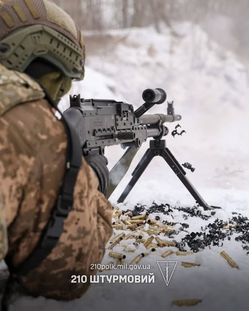 на засніженому полігоні український солдат у військовій формі веде вогонь із великокаліберного кулемета, про що свідчить розкидана на снігу стріляна гільза та напис «210 ШТУРМОВИЙ» на фото.