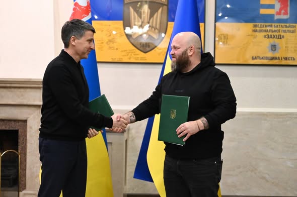Голова Луганської обласної військової адміністрації Олексій Харченко (праворуч) та голова Закарпатської обласної державної адміністрації Мирослав Білецький (ліворуч) потискають один одному руки після підписання Меморандуму про співпрацю щодо забезпечення луганчан житлом
