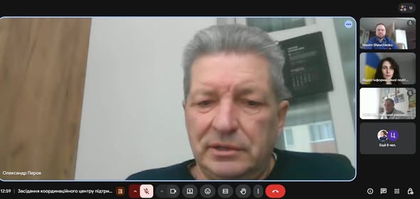 Скріншот відеоконференції. На великому екрані видно чоловіка на ім'я Олександр Перов, а праворуч — менші вікна інших учасників зустрічі