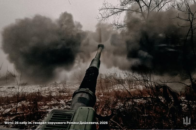 Фотографія зблизька артилерійської гармати 26-ї окремої артилерійської бригади імені генерал-хорунжого Романа Дашкевича під час пострілу, що здіймає велику хмару диму на засніженому полі.