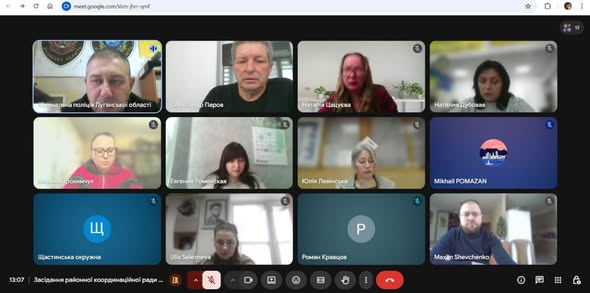 Зображення є скріншотом відеоконференції в Google Meet, що показує 12 учасників у різних віконцях, більшість з яких ідентифіковані написами з іменами та організаціями, а також нижньою панеллю керування та текстовим описом події: "Засідання районної координаційної ради".