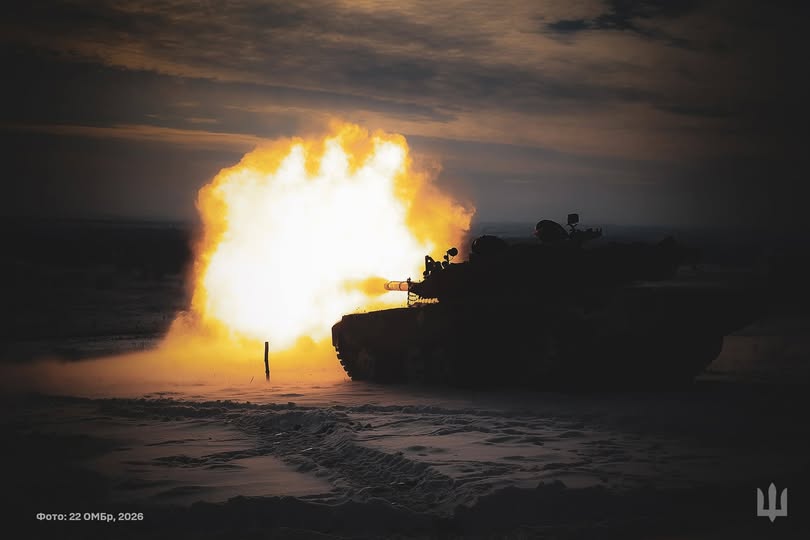 Танк, що перебуває в засніженій місцевості в сутінках або вночі, здійснює постріл, випускаючи великий яскравий спалах полум'я зі ствола