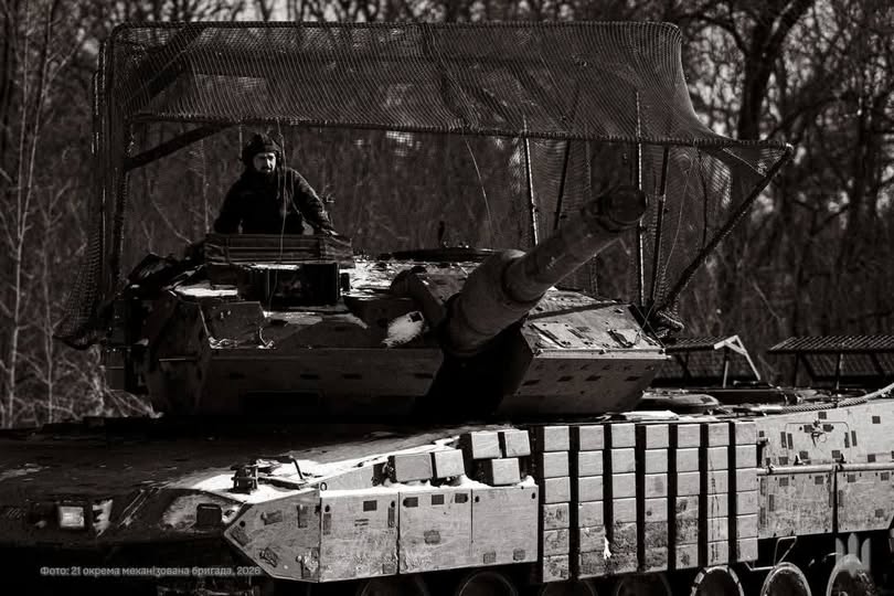 Чорно-біле фото українського танка Stridsvagn 122 зі складу 21-ї окремої механізованої бригади, оснащеного захисним «мангалом» над вежею та блоками динамічного захисту. 
