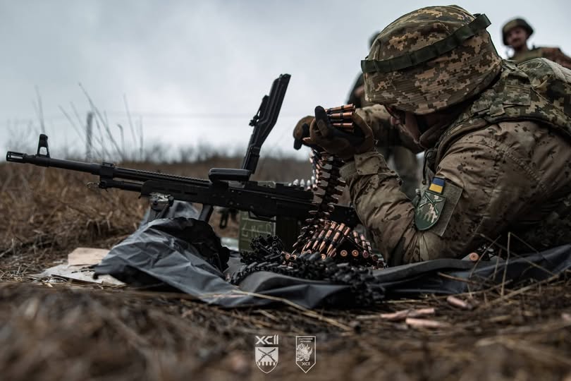 Український військовий споряджає кулеметною стрічкою ПКМ на бойовій позиції