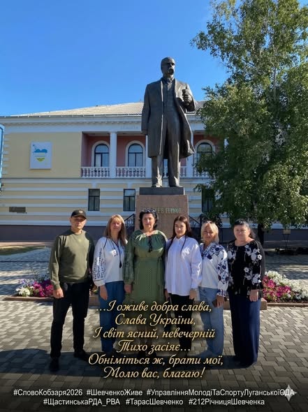 Група людей у патріотичному вбранні та вишиванках позує на фоні пам'ятника Тарасу Шевченку в Кропивницькому з нагоди 212-ї річниці від дня народження Кобзаря
