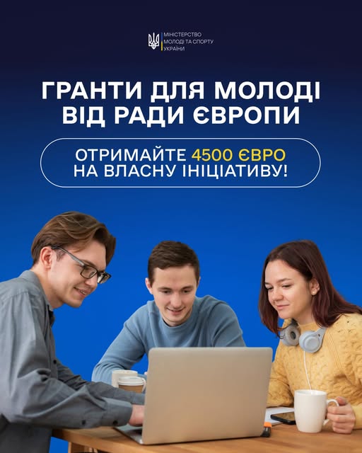 Три молодих людини — два хлопці та дівчина — зосереджено працюють за ноутбуком у сучасному офісі або коворкінгу на синьому фоні під заголовком про гранти для молоді від Ради Європи