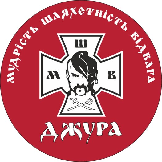 Це кругла емблема на червоному фоні, у центрі якої розміщено білий козацький хрест із зображенням голови козака з довгим оселедцем, перехрещеними шаблею та булавою внизу, літерами «М», «Ш», «В» на променях та великим написом «ДЖУРА» під ним, а вздовж верхнього краю півколом розташовано девіз «МУДРІСТЬ ШЛЯХЕТНІСТЬ ВІДВАГА»