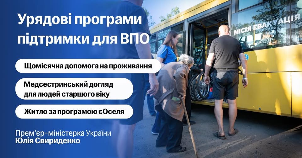 Інформаційний банер із синім градієнтом ліворуч містить великі білі написи про урядові програми підтримки для ВПО та цитату Юлії Свириденко, а з правого боку зображено реалістичне фото процесу евакуації біля жовтого автобуса з написом «МІСІЯ ЕВАКУАЦІЯ», де волонтери допомагають літній жінці з палицею та чоловіку у кріслі колісному піднятися в салон
