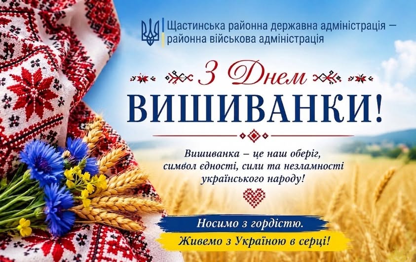 Святкова листівка від Щастинської РДА на тлі блакитного неба та пшеничного поля містить великий привітальний напис «З Днем ВИШИВАНКИ!», патріотичні гасла про вишиванку як оберіг та букет синіх волошок і колосків, що лежить на біло-червоному вишитому рушнику.