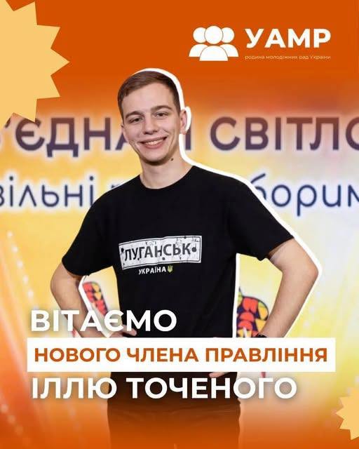 На помаранчевому фоні з логотипом «УАМР» та вітальним текстом усміхнено позирує молодий чоловік, Ілля Точений, у чорній футболці з написом «Луганськ. Україна».