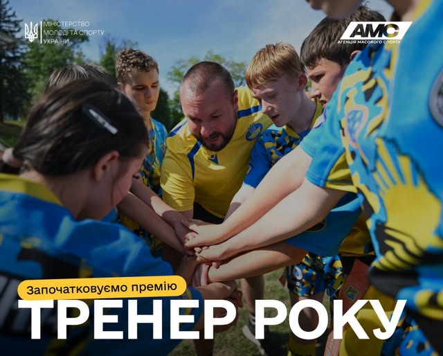 На фото зображено групу юних спортсменів у синьо-жовтій формі та їхнього тренера, які зібралися в коло на відкритому повітрі та склали руки разом у центрі, що символізує командну єдність, а внизу розміщено напис «Започатковуємо премію ТРЕНЕР РОКУ»