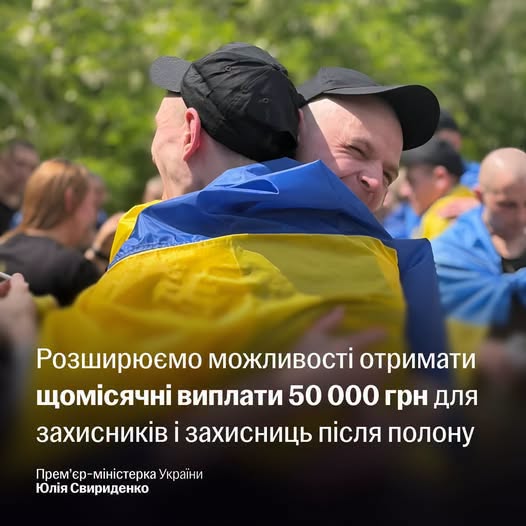 На зображенні двоє українських військових у чорних кепках радісно обіймаються на тлі інших людей, причому один із них загорнутий у синьо-жовтий прапор України, а внизу розміщено текст про щомісячні виплати 50 000 грн для захисників після полону від імені Юлії Свириденко.