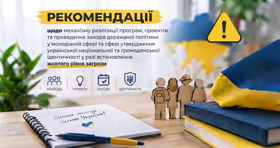 Інформаційний плакат містить текст українською мовою про рекомендації щодо реалізації молодіжної політики за жовтого рівня загрози, а на передньому плані зображено робочий стіл із розгорнутим блокнотом, де написано «Сильна молодь сильна Україна!», книгами, прапором України, дерев'яними фігурками людей та знаком оклику в жовтому трикутнику