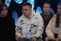 У центрі кадру — чоловік у окулярах, який активно щось пояснює.