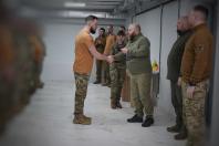На фото зображено офіційну церемонію нагородження в одному з підрозділів Сил територіальної оборони ЗСУ, що проходить у приміщенні штабного типу