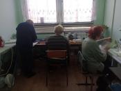 На фото зображено невелику швейну майстерню, де працюють троє жінок.