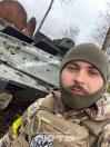 На цьому селфі-знімку зображений український захисник на фоні пошкодженої військової техніки