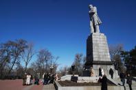 Група людей зібралася біля підніжжя високого пам’ятника Тарасу Шевченку на Монастирському острові в Дніпрі сонячного весняного дня