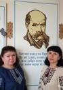 Дві жінки у вишиванках позують на фоні портрета Тараса Шевченка, доповненого його ліричними рядками про любов до України