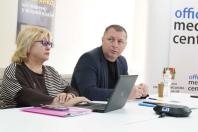 На світлині зображені жінка в окулярах та чоловік за ноутбуком під час ділової зустрічі або пресконференції в офіційному медіацентрі Луганської обласної військової адміністрації.