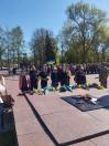 У нижній правій частині кадру розташований Вічний вогонь. Полум'я виходить із центру металевої п'ятикутної зірки, встановленої на підвищенні з червоних гранітних плит. Поряд із вогнем на плитах лежить солдатська каска та багато квітів — переважно жовтих і блакитних хризантем та червоних гвоздик
