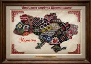 Картина у дерев'яній рамці, на якій зображено мапу України, вишиту різнокольоровим бісером, де кожна область має свій унікальний традиційний орнамент, із написами «"Вишивана стрічка Щастинщини"» зверху та «Україна» знизу.