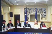 Шість офіційних представників сидять за президією під час офіційної зустрічі на тлі прапорів Європейського Союзу та України у класично оформленому залі.