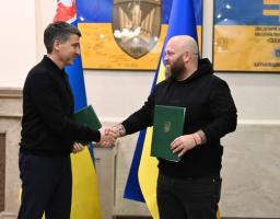 Голова Луганської обласної військової адміністрації Олексій Харченко (праворуч) та голова Закарпатської обласної державної адміністрації Мирослав Білецький (ліворуч) потискають один одному руки після підписання Меморандуму про співпрацю щодо забезпечення луганчан житлом
