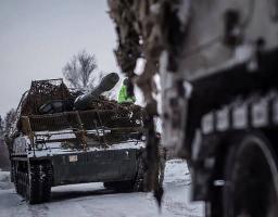 На знімку, зробленому взимку, зображено самохідну артилерійську установку PzH 2000 Збройних сил України, яка рухається засніженою дорогою, а перед нею частково видно іншу броньовану машину