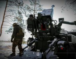 На фото зображено військовослужбовців 30-ї окремої механізованої бригади імені князя Костянтина Острозького, які працюють біля самохідної артилерійської установки в засніженому лісі