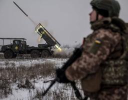 Військовослужбовець 24-ї ОМБр імені короля Данила спостерігає за залпом реактивної системи залпового вогню БМ-21 «Град» на засніженому полі. Ракета вилітає з установки, залишаючи яскравий вогняний слід