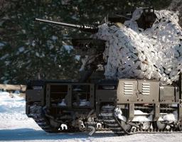 Бойовий наземний роботизований комплекс (НРК) 61-ї окремої механізованої Степової бригади на засніженій позиції. Гусенична платформа оснащена кулеметом і частково вкрита білою маскувальною сіткою
