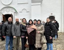 На цьому фото зафіксовано групу людей (три чоловіки та чотири жінки), які позують для спільного знімка на тлі великої білої будівлі.