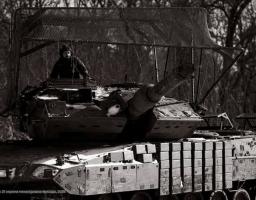Чорно-біле фото українського танка Stridsvagn 122 зі складу 21-ї окремої механізованої бригади, оснащеного захисним «мангалом» над вежею та блоками динамічного захисту. 