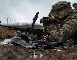 Український військовий споряджає кулеметною стрічкою ПКМ на бойовій позиції