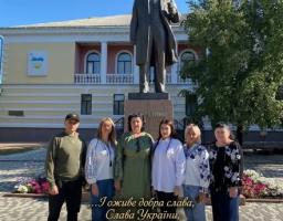 Група людей у патріотичному вбранні та вишиванках позує на фоні пам'ятника Тарасу Шевченку в Кропивницькому з нагоди 212-ї річниці від дня народження Кобзаря