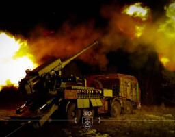 Українська самохідна артилерійська установка «Богдана» веде вогонь по ворожих позиціях у нічний час, створюючи яскраві спалахи від пострілів