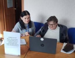 Світлина демонструє процес надання цифрових адміністративних послуг населенню, де фахівець допомагає громадянці похилого віку розібратися з електронними сервісами або оформити необхідні документи онлайн.