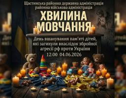 Інформаційний банер Щастинської РДА закликає до «Хвилини мовчання» у День вшанування пам'яті дітей, які загинули внаслідок збройної агресії рф проти України, на тлі меморіальної композиції з дитячими іграшками, запаленими свічками та прапором України