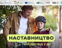 Інформаційний банер програми «НАСТАВНИЦТВО — твій досвід у дії» із зображенням усміхненого кучерявого чоловіка, який притискає до себе хлопчика у велосипедному шоломі, та довгою лінією партнерських логотипів державних і міжнародних організацій у верхній частині кадру