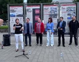 На зображенні по центру крупним планом показано українського військового у камуфляжній формі та коричневому береті, який тримає руку на зброї, на тлі інших бійців у строю, поверх яких по центру накладено великий жовтий напис «НАЦІОНАЛЬНИЙ СПРОТИВ»