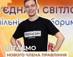 На помаранчевому фоні з логотипом «УАМР» та вітальним текстом усміхнено позирує молодий чоловік, Ілля Точений, у чорній футболці з написом «Луганськ. Україна».