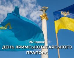 Празничний банер до Дня кримськотатарського прапора із зображенням блакитного прапора з золотою тамгою та державного прапора України, що майорять на тлі Монумента Незалежності в Києві під ясним синім небом