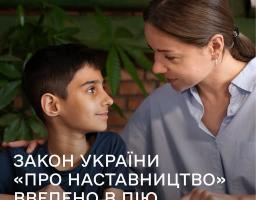 Інформаційний банер із написом «ЗАКОН УКРАЇНИ «ПРО НАСТАВНИЦТВО» ВВЕДЕНО В ДІЮ» та бірюзовою кнопкою «Що це означає?», на якому зображено жінку, що ніжно спілкується з хлопчиком біля розгорнутої книги на тлі цегляної стіни.