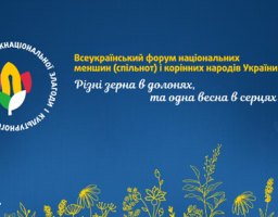 На синьому інформаційному банері, прикрашеному силуетами жовтих польових квітів у нижній частині, розміщено анонс «Всеукраїнського форуму національних меншин (спільнот) і корінних народів України» з поетичним гаслом «Різні зерна в долонях, та одна весна в серцях», а також кругла емблема Дня міжнаціональної злагоди та логотипи ДЕСС і «Безбар’єрність»